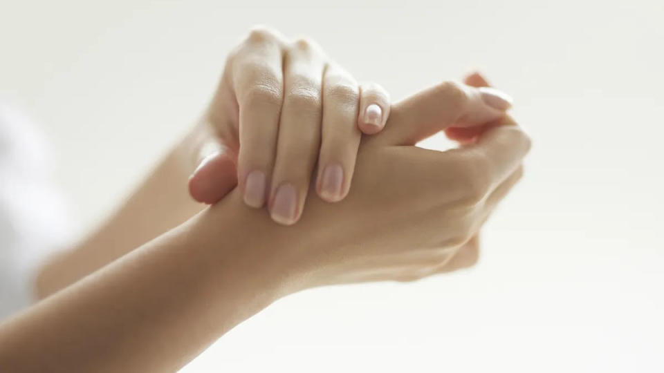 Image shows a woman's hands with healthy nails