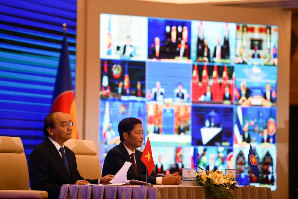 Vietnam's Prime Minister Nguyen Xuan Phuc and Minister of Industry and Trade Tran Tuan Anh (R) attend the signing ceremony for the Regional Comprehensive Economic Partnership (RCEP) trade pact at the ASEAN summit that is being held online in Hanoi on November 15, 2020. (Photo by Nhac NGUYEN / AFP) (Photo by NHAC NGUYEN/AFP via Getty Images)