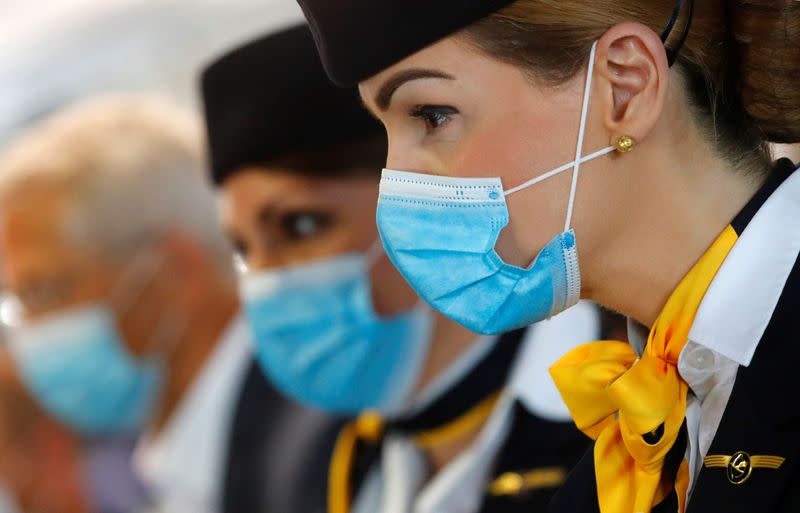 FILE PHOTO: Employees of German airline Lufthansa wait for passengers at a boarding gate at the airport in Frankfurt