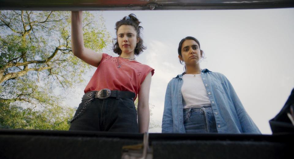 Lesbian friends Jamie (Margaret Qualley, left) and Marian (Geraldine Viswanathan) find something strange in their rental car on the way to Florida in the noir comedy "Drive-Away Dolls."