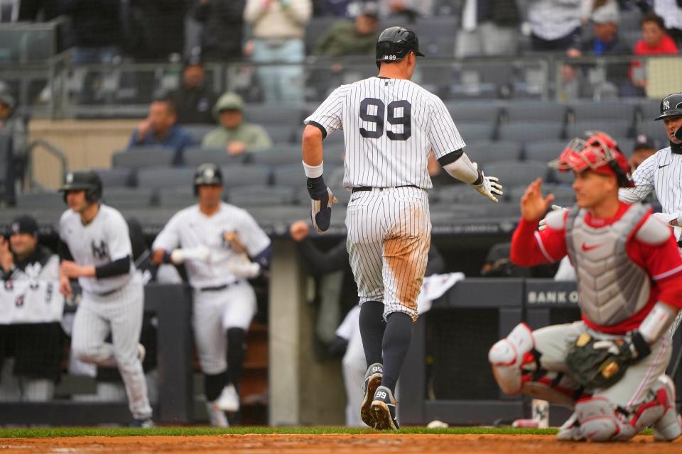 Apr 5, 2023; Bronx, New York, USA; New York Yankees center fielder Aaron Judge (99) scores a run against the Philadelphia Phillies on New York Yankees designated hitter Gleybor Torres (25) (not pictured) RBI single during the first inning at Yankee Stadium. Mandatory Credit: Gregory Fisher-USA TODAY Sports