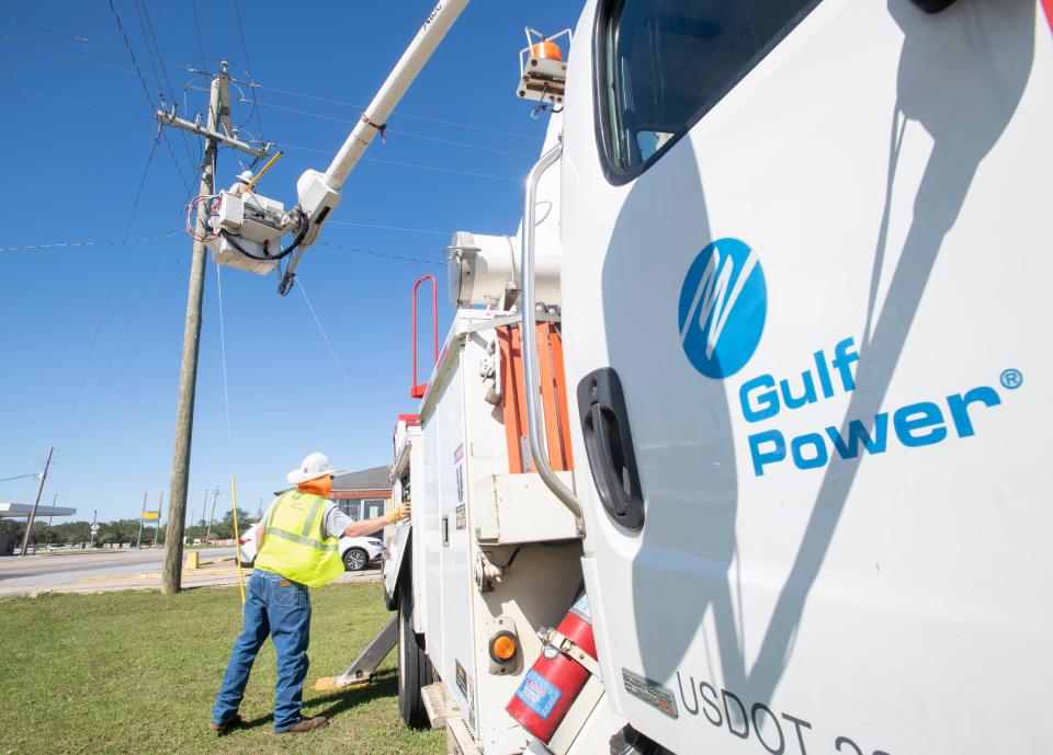 Gulf Power linemen Christian Grissom, top, and Jacob Randall change out a fuse Oct. 29, 2020, along Mobile Highway in Pensacola after Hurricane Zeta passed through the area.