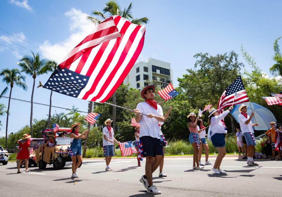 A parade participant waves the American flag at an Independence Day celebration on Thursday, July 4, 2024 in Key Biscayne, Fla. The Key Biscayne July Fourth parade is one of the oldest parades in South Florida, starting in 1959 and celebrating its 65th year.