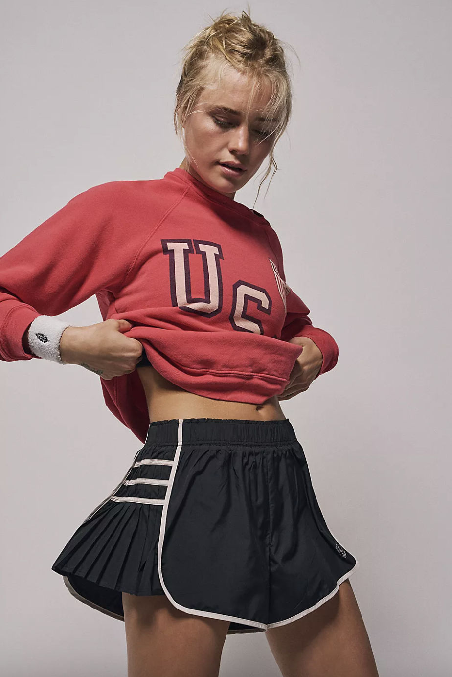 blonde model wearing red sweater and black Easy Tiger Shorts (photo via FP Movement)