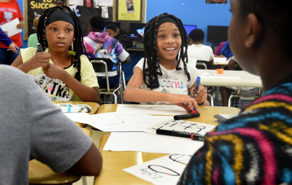 FILE - Makayla Cushman, 11, (left) and Seryah Scriven, 9, work on programming their Ozobot robots during the summer Cyber Camp at Richmond County Technical Career Magnet School in Augusta, Ga., on June 12, 2019. RCTCM scored high marks in multiple factors of the most recent version of Georgia's College and Career Ready Performance Index.