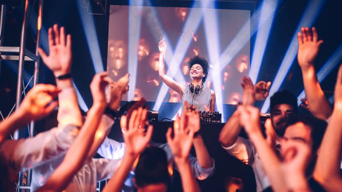 Shot of a female DJ playing music in the club.