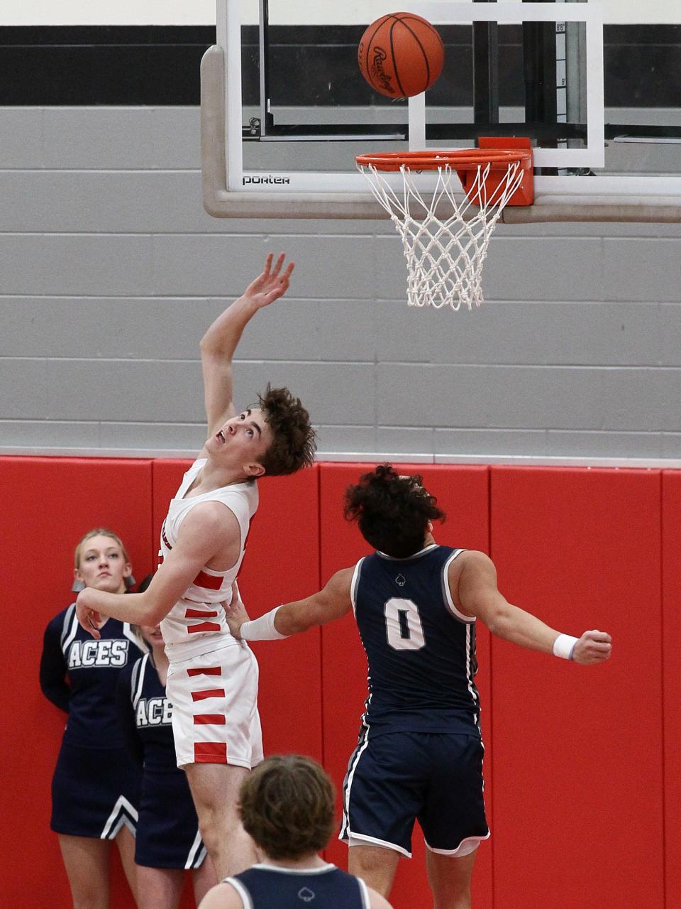 Johnstown senior Drew Brett makes a difficult shot over Granville junior Dante Varrasso Wednesday night during the Johnnies' 49-31 victory over the visiting Blue Aces.