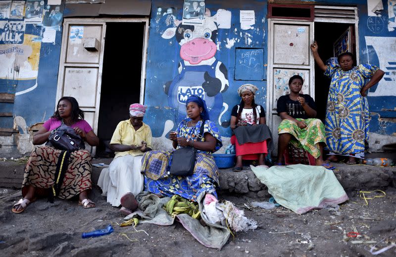 FILE PHOTO: Traders sit near a deserted crossing point between the Democratic Republic of Congo and Rwanda amid concerns about the spread of coronavirus disease (COVID-19), at the Petite Barriere in Goma