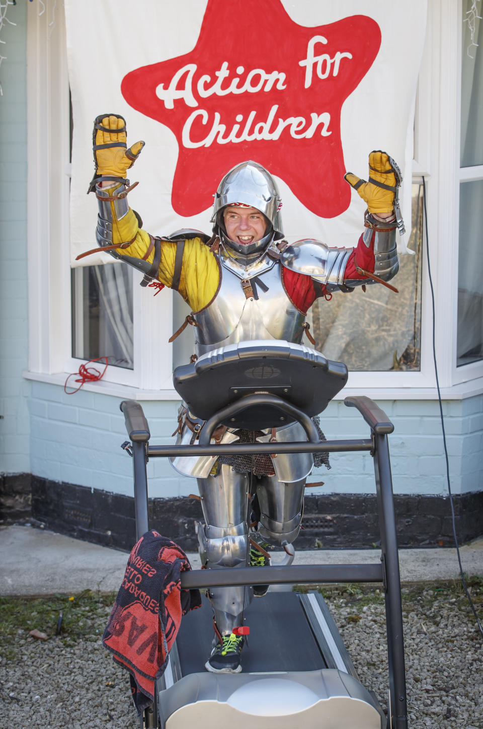 Mike Manders, 34, celebrates as he completes the postponed Hull 10k while dressed in a suit of armour using a treadmill in his front garden in Hull, whilst the UK continues in lockdown to help curb the spread of the coronavirus.