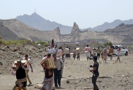 People carry ammunition boxes they took from army depots in Yemen's southern port city of Aden March 27, 2015. REUTERS/Anees Manousr