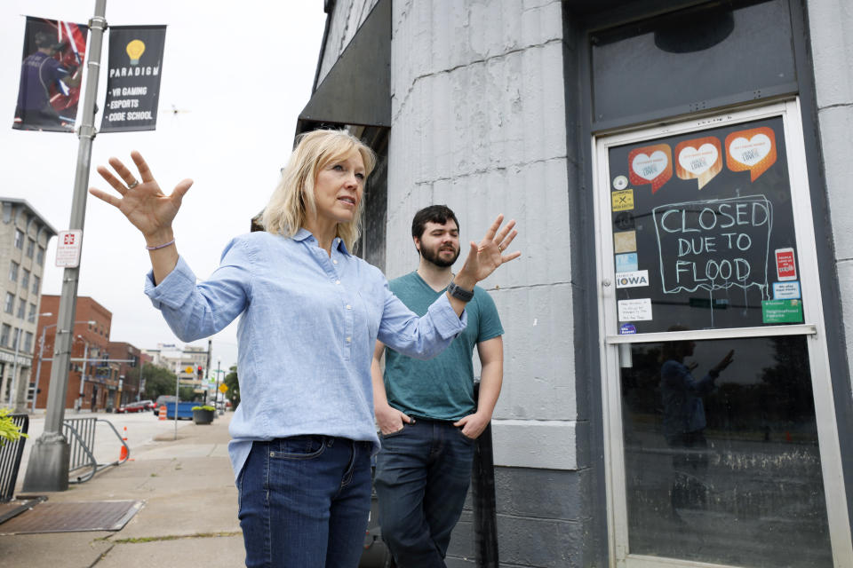 Kelli Grubbs and her son Justin stand in front of flood closed micro brewery adjacent to their business, Tuesday, July 16, 2019, in Davenport, Iowa. Hundreds of communities line the Mississippi River, but Davenport is among the few where people can dip their toes into the water without scaling a flood wall or levee. (AP Photo/Charlie Neibergall)