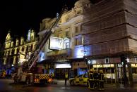 Emergency services look at the roof of the Apollo Theatre on Shaftesbury Avenue after part of the ceiling collapsed in central London December 19, 2013. Emergency services said nearly 90 people had been injured in a packed London theatre on Thursday when part of the ceiling collapsed during a performance, bringing the city's West End theatre district to a standstill.The audience was showered with masonry and debris following the incident at the Apollo Theatre, where about 720 people including many families were watching the hugely popular play "The Curious Incident of the Dog in the Night-Time". REUTERS/Neil Hall (BRITAIN - Tags: DISASTER ENTERTAINMENT)