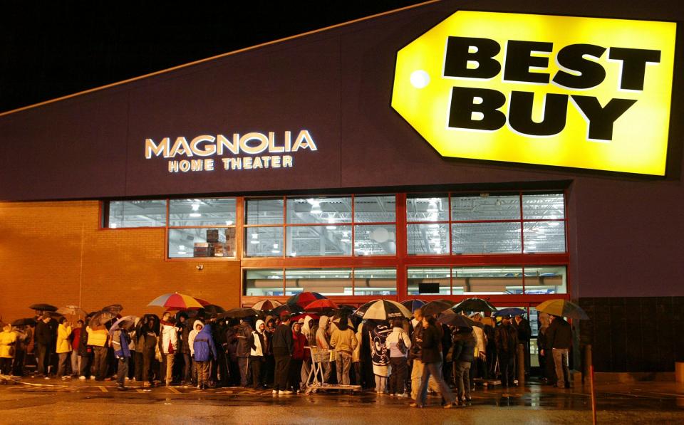 Holiday shoppers stand in line in the rain outside a Best Buy in Warwick, R.I., waiting for the doors to open at 5:00 a.m., for Black Friday deals, on Nov. 24, 2006.