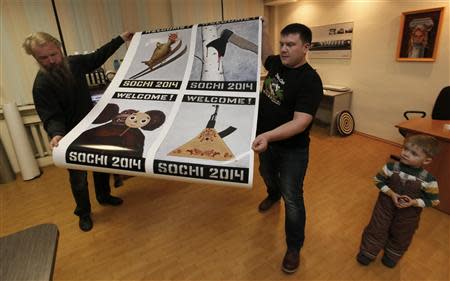 Russian artist Vasily Slonov (L) and an employee carry printed reproductions of oil paintings from the series "Welcome Sochi 2014" at a printing house in Russia's Siberian city of Krasnoyarsk, December 9, 2013. REUTERS/Ilya Naymushin