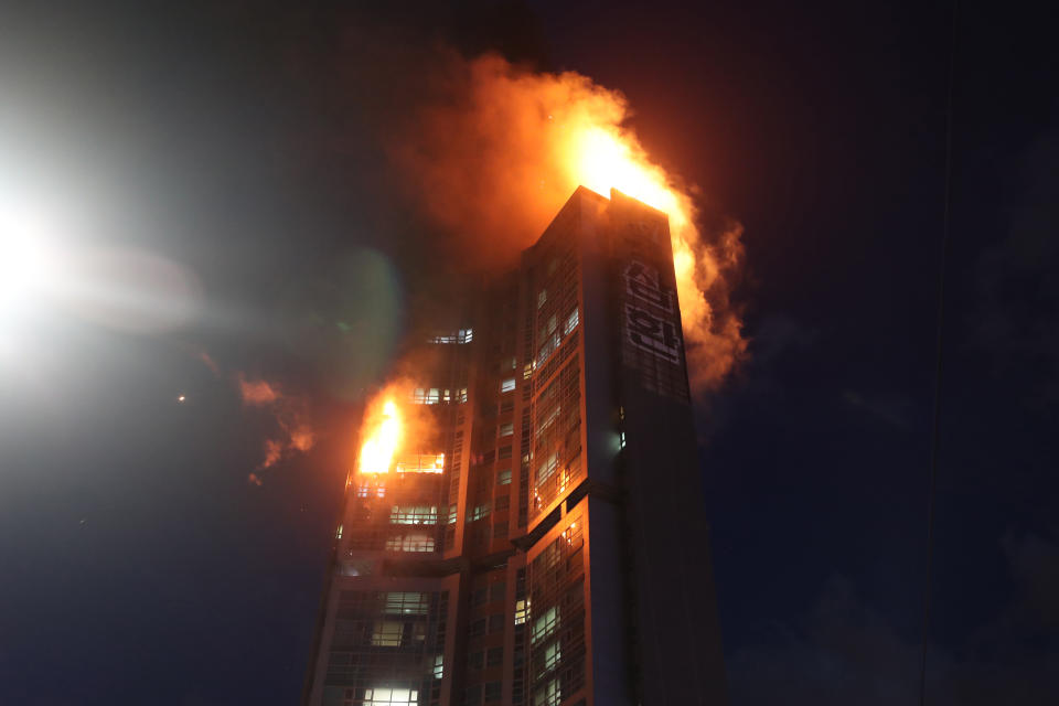 An apartment building is engulfed in a fire in Ulsan, South Korea, Friday, Oct. 9, 2020. A fire spread through the high-rise apartment building in the city early Friday, causing minor injuries to scores of people, officials said. (Kim Yong-tae/Yonhap via AP)