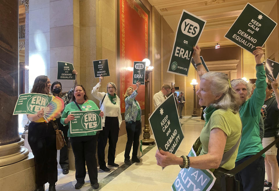 Supporters of a proposed Minnesota Equal Rights Amendment, known as the ERA, held signs support outside the Minnesota House in the State Capitol building in St. Paul, Minn., on May 17, 2024. The amendment would guarantee some of the nation's broadest protections of abortion and LGBTQ+ rights if it is approved by both chambers this session and then by voters in two years. (AP Photo/Trisha Ahmed)