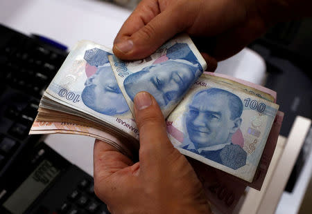 FILE PHOTO: A money changer counts Turkish lira banknotes at a currency exchange office in Istanbul, Turkey August 2, 2018. Picture taken August 2, 2018. REUTERS/Murad Sezer/File Photo