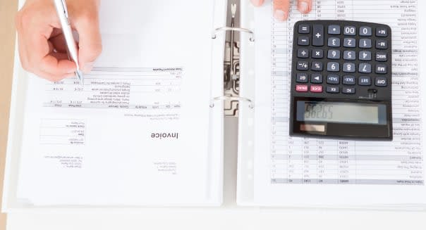 Man Calculating Home Finances At Table