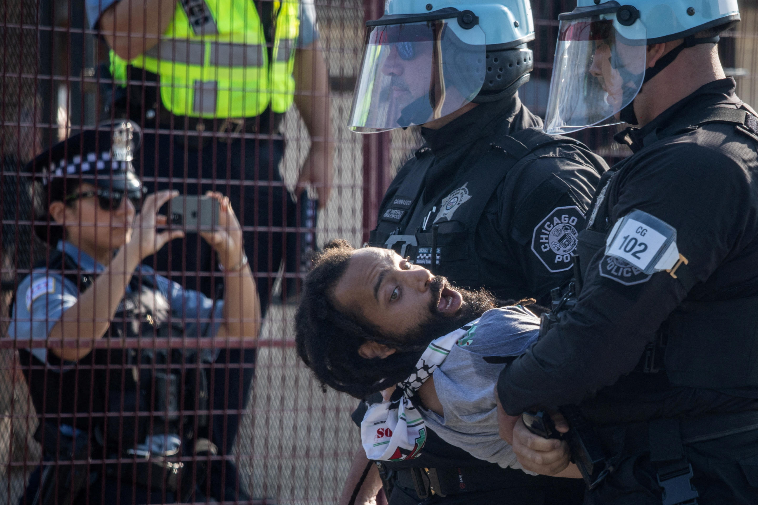 Police arrest a man after several protesters breached a security fence near the United Center during the Democratic National Convention in Chicago on Monday. (Adrees Latif/Reuters)