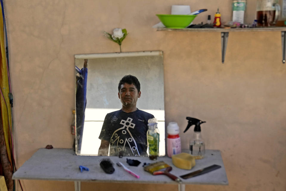 Hamid Mohammad, 28, an Afghan who has been in Indonesia for 11 years, looks into a mirror at a resort turned into a shelter for refugees, in Tanjungpinang, Bintan Island, Indonesia, Tuesday, May 14, 2024. Indonesia, despite having a long history of accepting refugees, is not a signatory to the U.N. Refugee Convention of 1951 and its 1967 Protocol, and the government does not allow refugees and asylum-seekers to work.(AP Photo/Dita Alangkara)