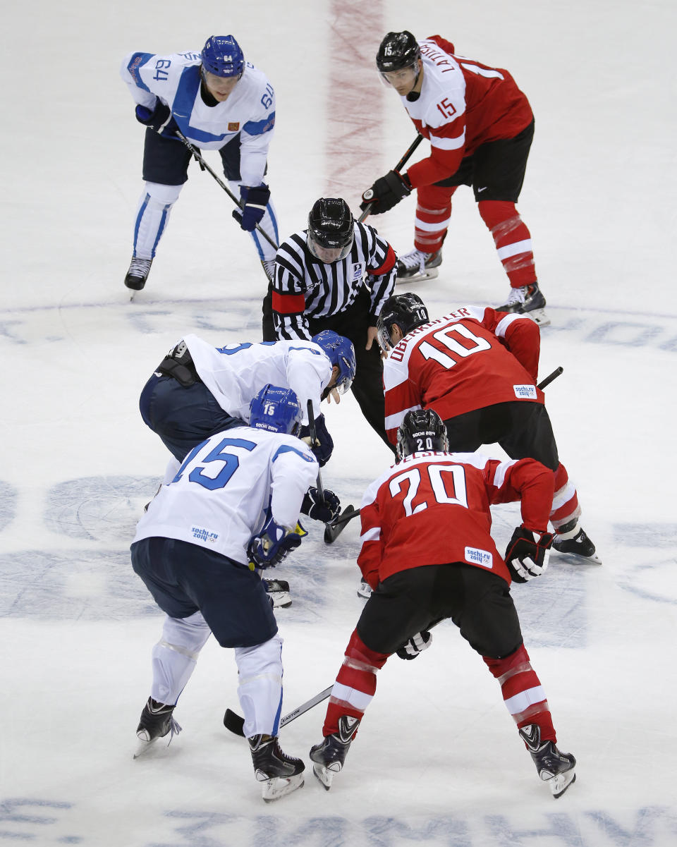 Team Finland and team Austria face off at the start of a men's ice hockey game at the 2014 Winter Olympics, Thursday, Feb. 13, 2014, in Sochi, Russia. (AP Photo/Mark Humphrey)
