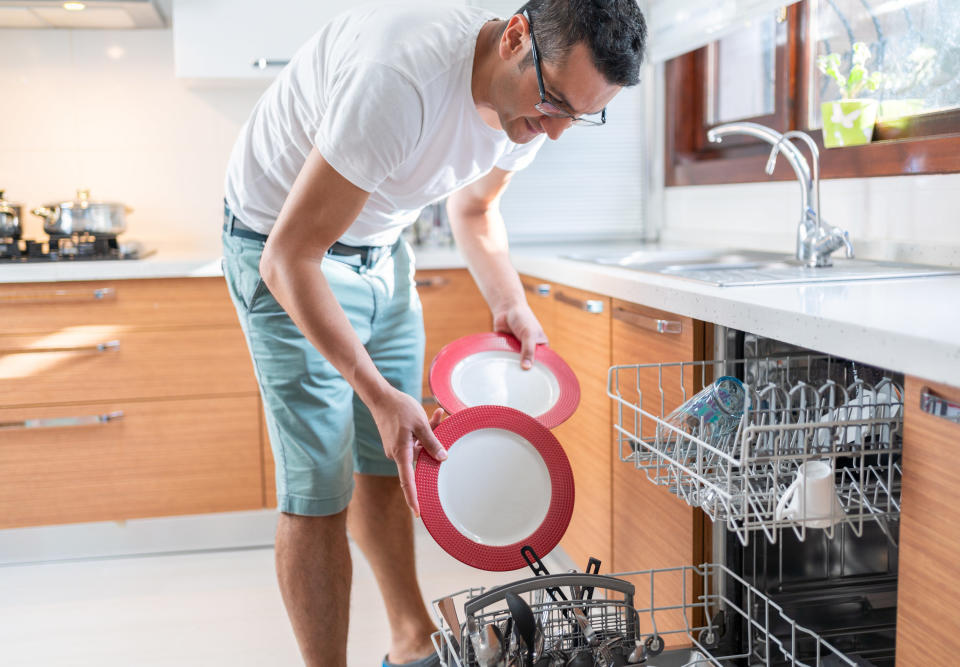 A person loading the dishwasher