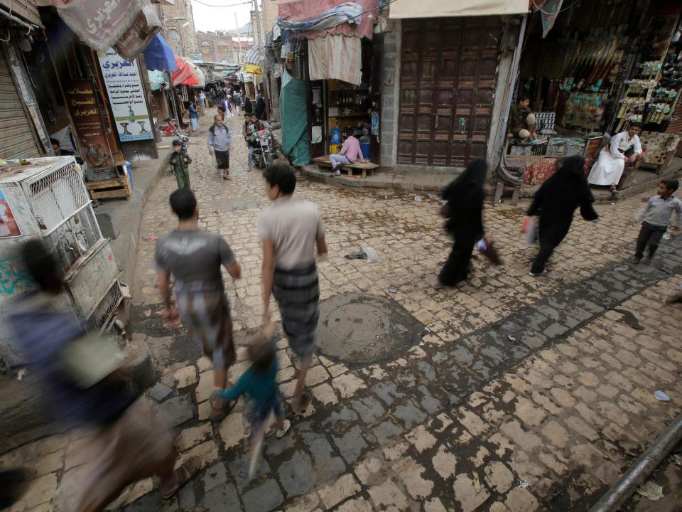 Yemenis walk past vendors in the market in the old city of Sanaa, Yemen, Saturday, Sept. 28, 2019.