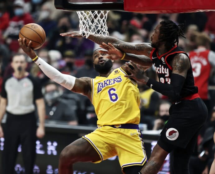 Lakers forward LeBron James, left, shoots as Portland Trail Blazers guard Ben McLemore, right, defends .