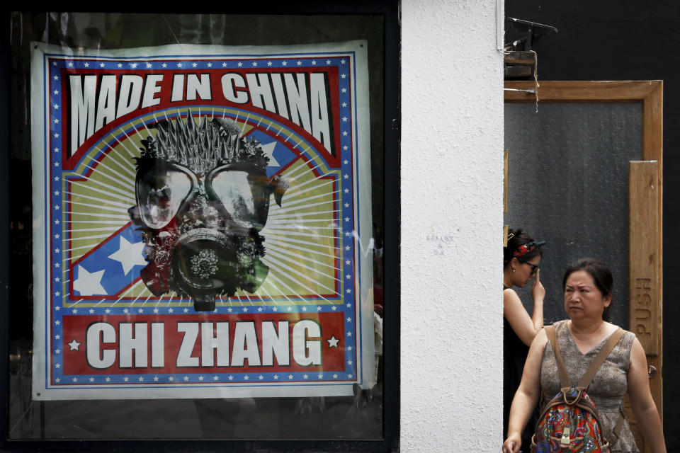 Women step out from a fashion boutique at the capital city's popular shopping mall in Beijing, Tuesday, June 25, 2019. China says its trade negotiators are talking to their U.S. counterparts on how to resolve disputes ahead of an expected meeting between their two heads of state at the G20 meeting in Japan later this week. (AP Photo/Andy Wong)