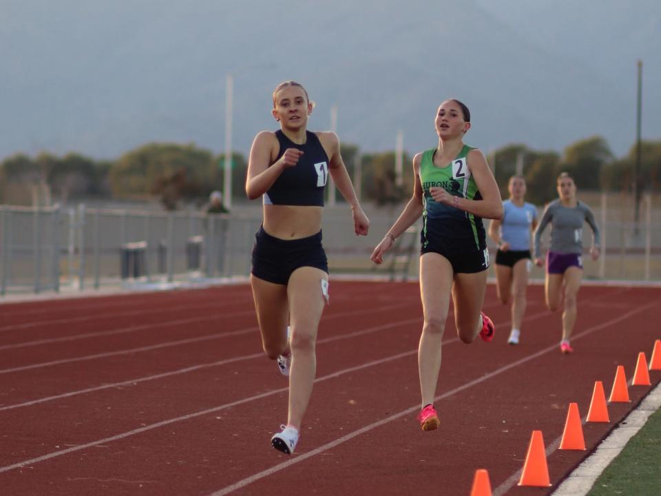 Millennium senior Landen LeBlond, left, and Highland sophomore, Camryn Delancey, right, compete in the 800-meters at the Distance in the Desert #2 meet on Jan. 13, 2024 at ALA West Foothills High School in Waddell, Ariz.