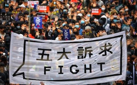 People hold a banner as they take part in an anti-government rally in Hong Kong - Credit: REX