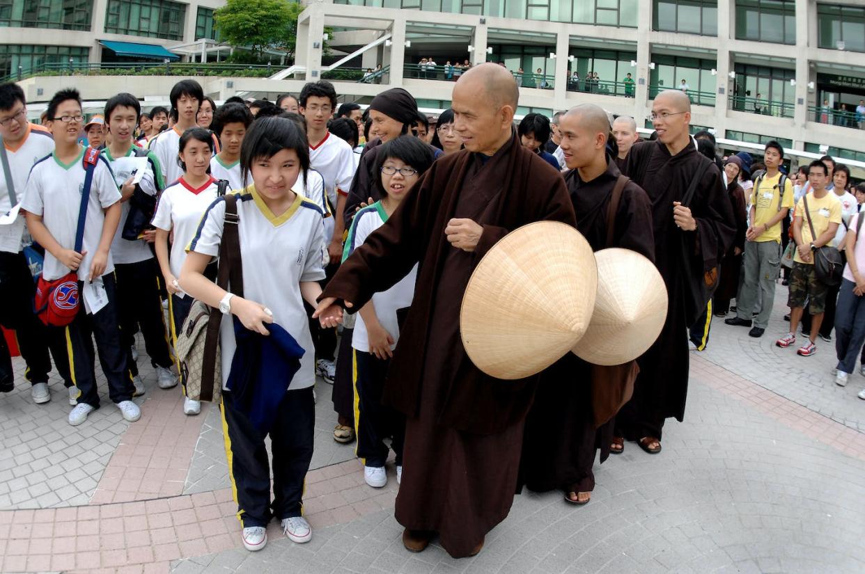 The late Zen master Thich Nhat Hanh leading a meditation walk. <a href="https://www.gettyimages.com/detail/news-photo/pupil-cheng-ka-ki-looks-surprised-as-zen-master-thich-nhat-news-photo/1125039441?phrase=walking%20mindfulness&adppopup=true" rel="nofollow noopener" target="_blank" data-ylk="slk:Steve Cray/South China Morning Post via Getty Images;elm:context_link;itc:0;sec:content-canvas" class="link ">Steve Cray/South China Morning Post via Getty Images</a>