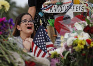 <p>Ariana Gonzalez is overcome with emotion as she visits a cross setup for her friend, football coach Aaron Feis, at the memorial in front of Marjory Stoneman Douglas High School as teachers and staff are allowed to return to the school for the first time since the mass shooting on campus in Parkland, Florida. Police arrested 19-year-old former student Nikolas Cruz for killing 17 people at the high school. (Joe Raedle/Getty Images) </p>