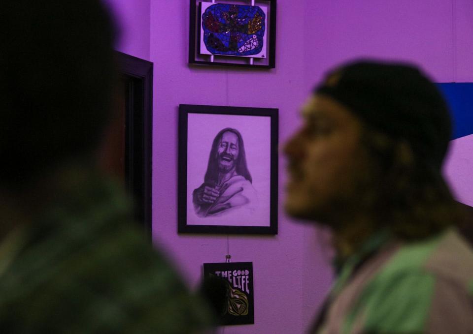 A portrait of Jesus is on display in the second-floor meeting room at the Salina Grace Resource Center, where a community member asks a question during a public forum.