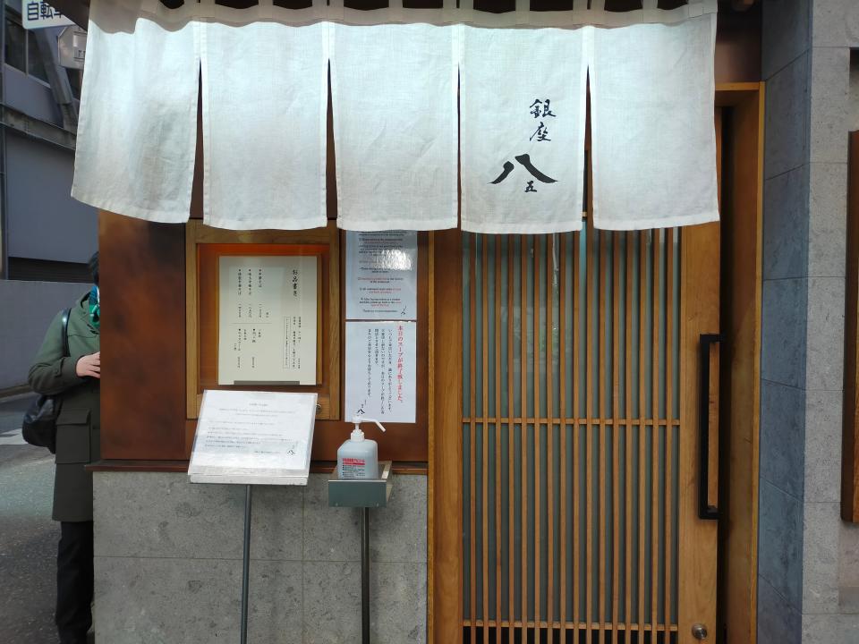 Chukasoba Ginza Hachigou closeup of exterior door with white curtains above the door