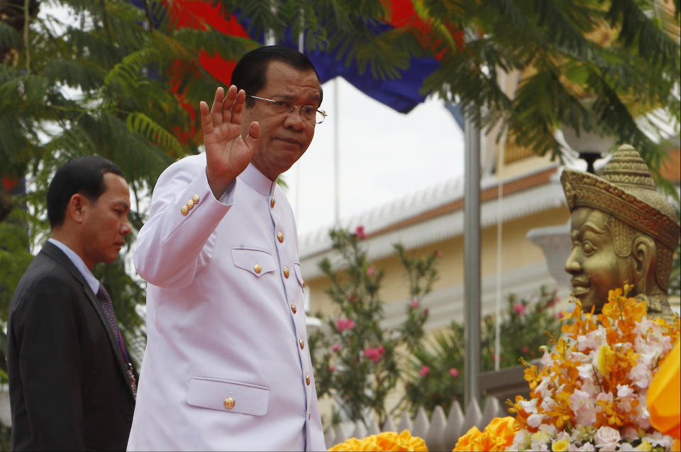 Cambodia's Prime Minister Hun Sen, right, arrives in front of the National Assembly in Phnom Penh, Cambodia, Wednesday, Sept. 5, 2018. Cambodia National Assembly on Wednesday opening its the first session presided over by King Norodom Sihamoni to ensure long-ruling Prime Minister Hun Sen another term after his party swept election in late July. (AP Photo/Heng Sinith)