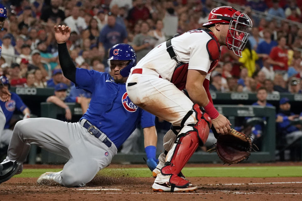 Chicago Cubs' Seiya Suzuki, left, scores past St. Louis Cardinals catcher Andrew Knizner during the sixth inning of a baseball game Friday, July 28, 2023, in St. Louis. (AP Photo/Jeff Roberson)