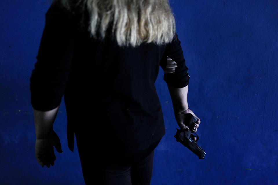 A resident who did not want to be identified shows the gun she keeps at her home for self-defense as she poses for a photo in Rosario, Argentina, Monday, April 8, 2024. (AP Photo/Natacha Pisarenko)