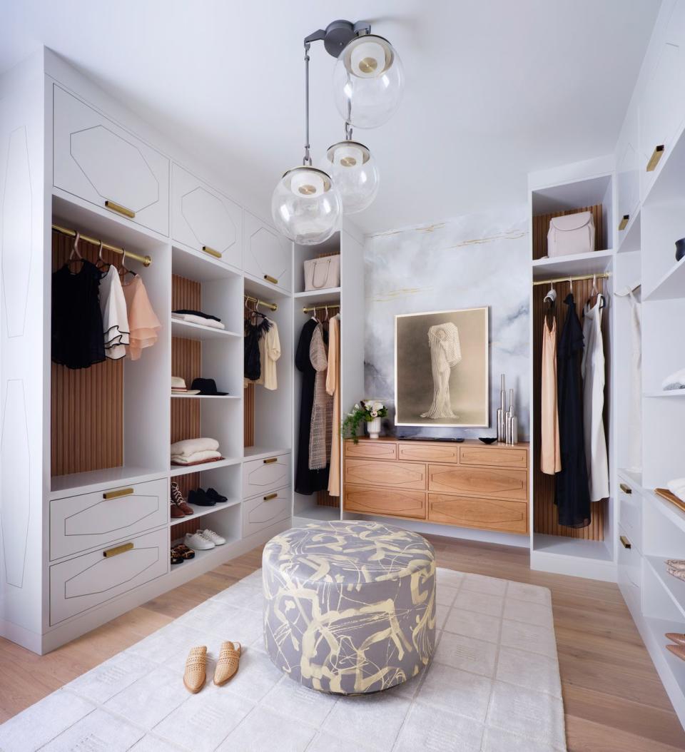 walk in closet with art and ottoman