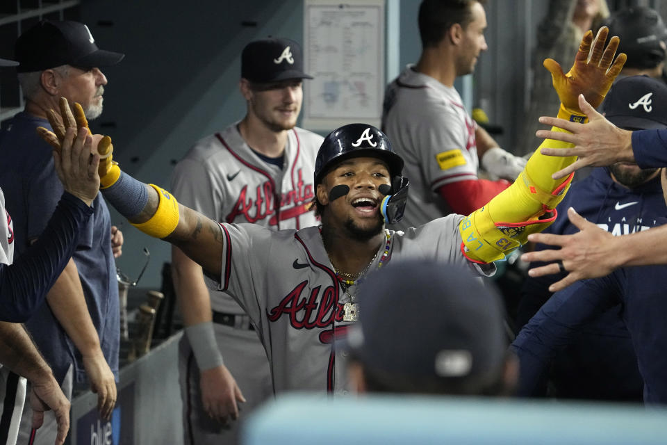 Atlanta Braves' Ronald Acuna Jr. is congratulated by teammates in the dugout after hitting a solo home run during the third inning of a baseball game against the Los Angeles Dodgers Friday, Sept. 1, 2023, in Los Angeles. (AP Photo/Mark J. Terrill)