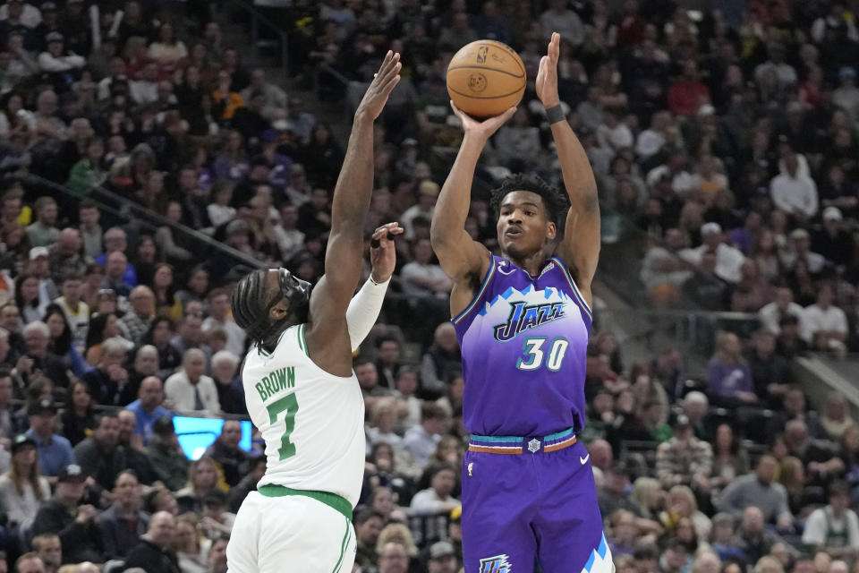 Utah Jazz guard Ochai Agbaji (30) shoots as Boston Celtics guard Jaylen Brown (7) defends during the second half of an NBA basketball game, Saturday, March 18, 2023, in Salt Lake City. (AP Photo/Rick Bowmer)