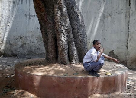A student eats his free mid-day meal distributed by municipal workers at a government school in New Delhi, India, May 6, 2015. REUTERS/Anindito Mukherjee