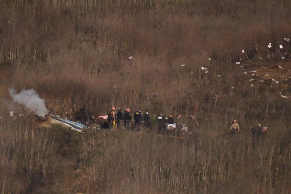 A body is carried from the scene of a helicopter crash that killed former NBA basketball player Kobe Bryant, his daughter and several others in Calabasas, Calif., Sunday, Jan. 26, 2020. (AP Photo/Kelvin Kuo)