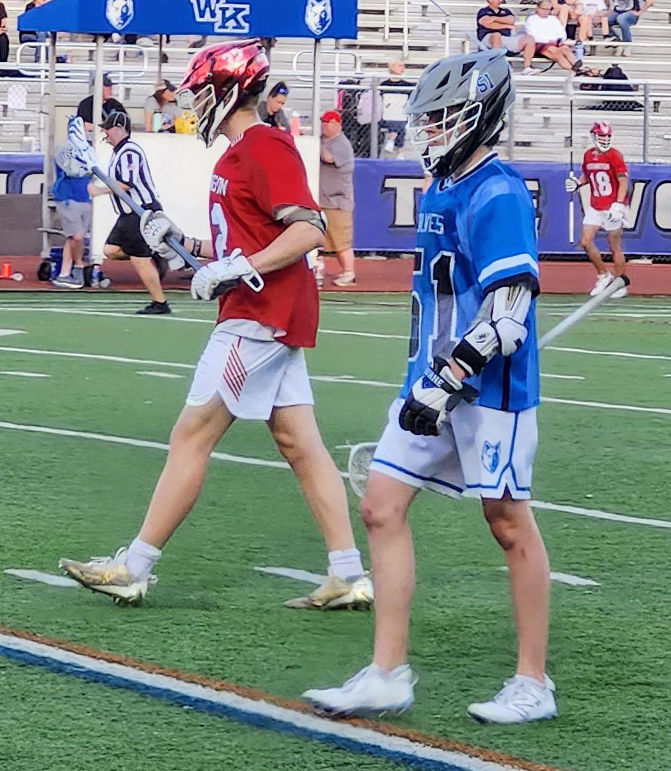 Worthington Kilbourne's Thomas Tyack, right, and Thomas Worthington's Daniel Long wait for play to resume during the first half of their game Sunday. Tyack, a junior, scored five goals in the Wolves' 16-5 win.