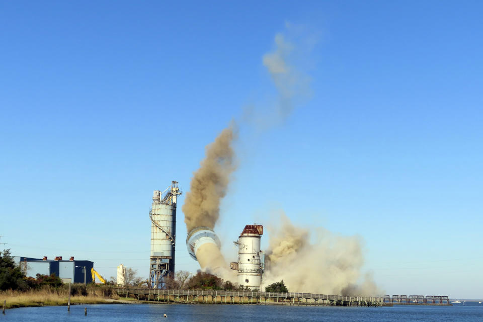 The smokestack at the former B.L. England power plant in Upper Township, N.J., is toppled during a control demolition, Thursday, Oct. 26, 2023. The site will be redeveloped as a mixed use residential and commercial project, and a nearby electrical substation will be used to connect New Jersey's soon-to-come offshore wind farms with the electrical grid. (AP Photo/Wayne Parry)