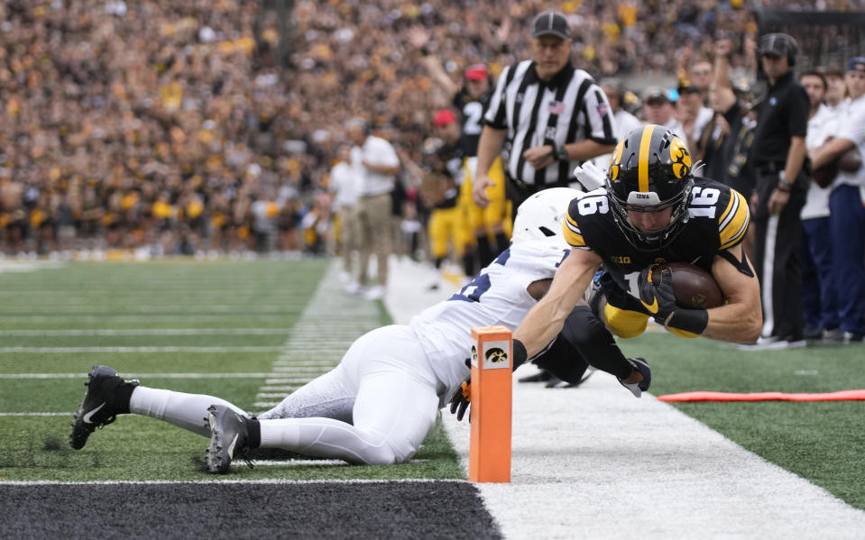 Iowa wide receiver Charlie Jones (16) dives for a touchdown despited defensive efforts by Penn State safety Ji'Ayir Brown (16) during the first half of an NCAA college football game, Saturday, Oct. 9, 2021, in Iowa City, Iowa. (AP Photo/Matthew Putney)