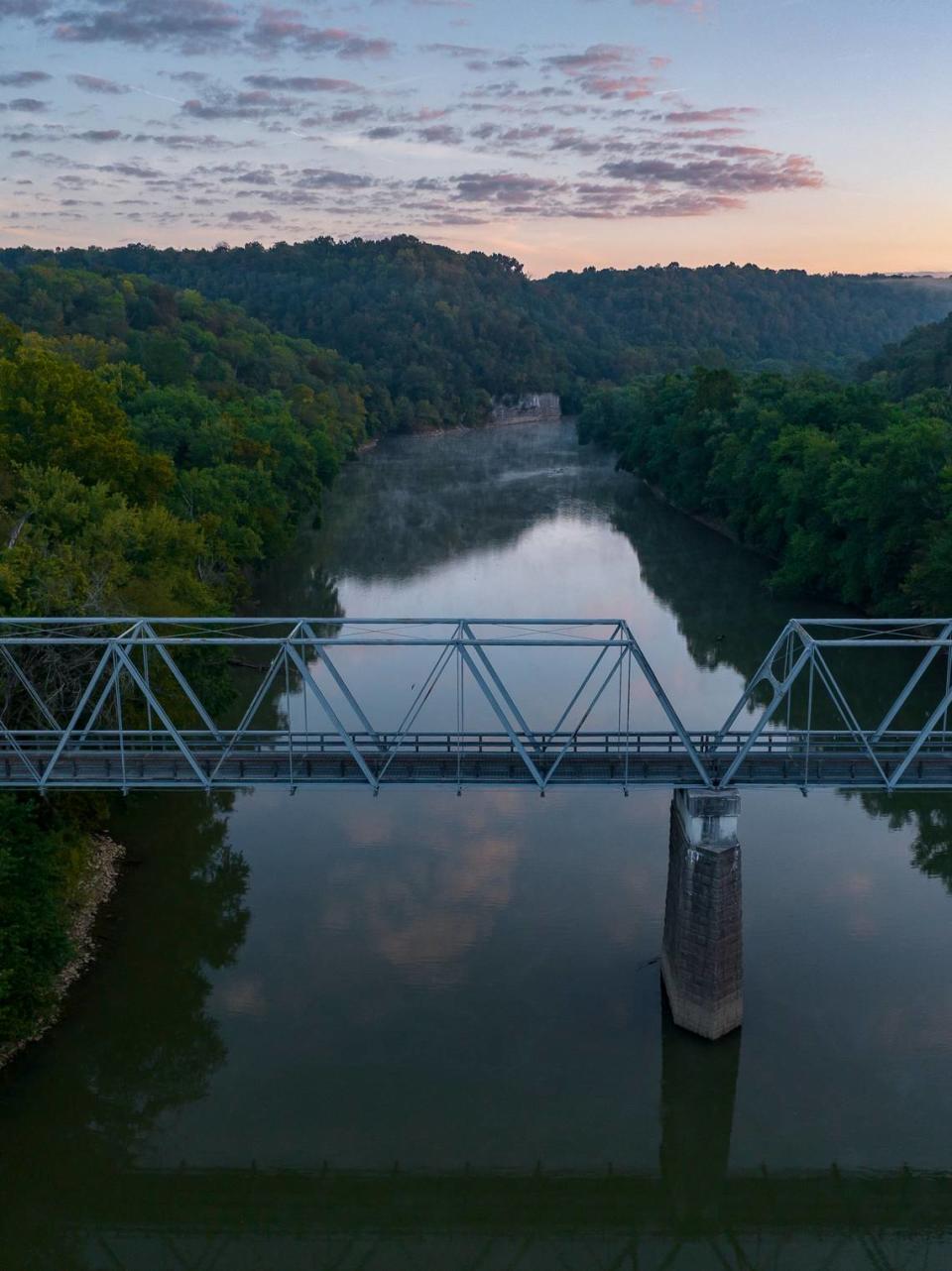 The sun rises over the Old Clay’s Ferry Bridge crossing the Kentucky River at the Fayette and Madison county line, Sept. 19, 2023.