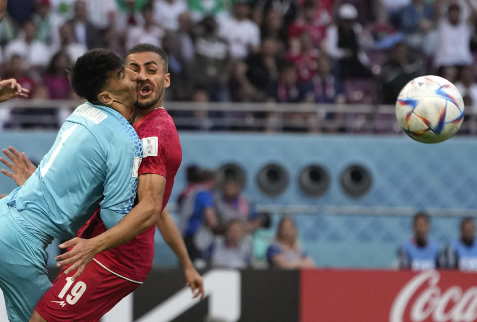 Iran's goalkeeper Alireza Beiranvand collides with Iran's Majid Hosseini, right, during the World Cup group B soccer match between England and Iran at the Khalifa International Stadium in Doha, Qatar, Monday, Nov. 21, 2022. (AP Photo/Alessandra Tarantino)