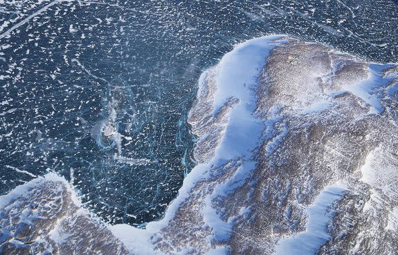 Sea ice (TOP) meets land as seen from NASA's Operation IceBridge research aircraft above Greenland.