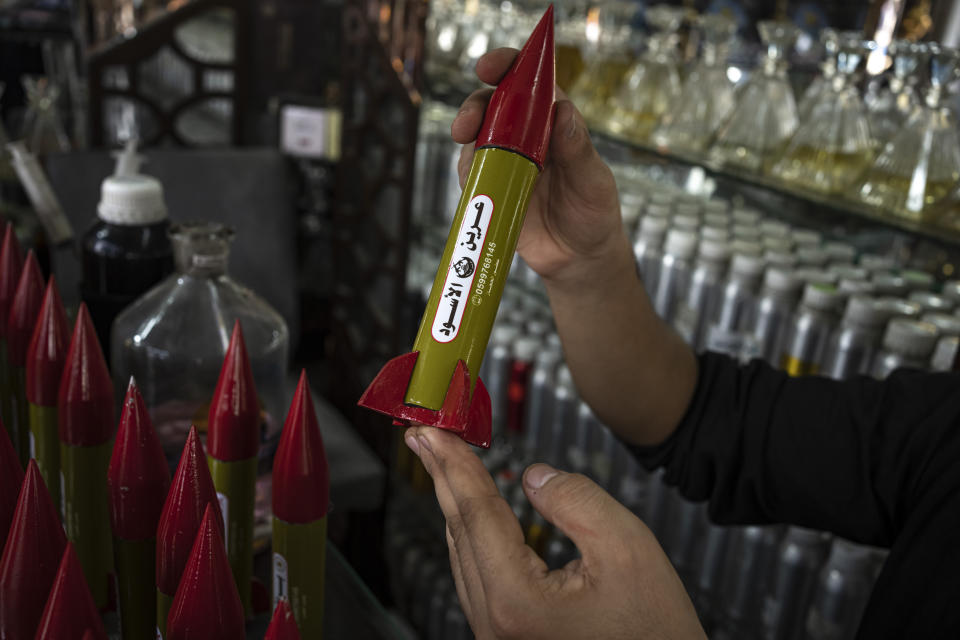 Belal Abu Saraya poses with a perfume container representing rockets used against Israel in a perfume store against Israel in past conflicts at his shop in Gaza City on Thursday, Oct. 5, 2023. AP Photo/Fatima Shbair)